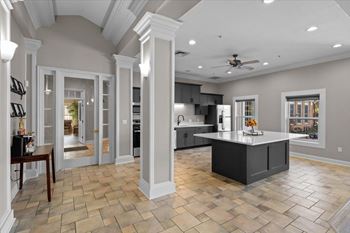 A spacious kitchen with a central island and a ceiling fan.